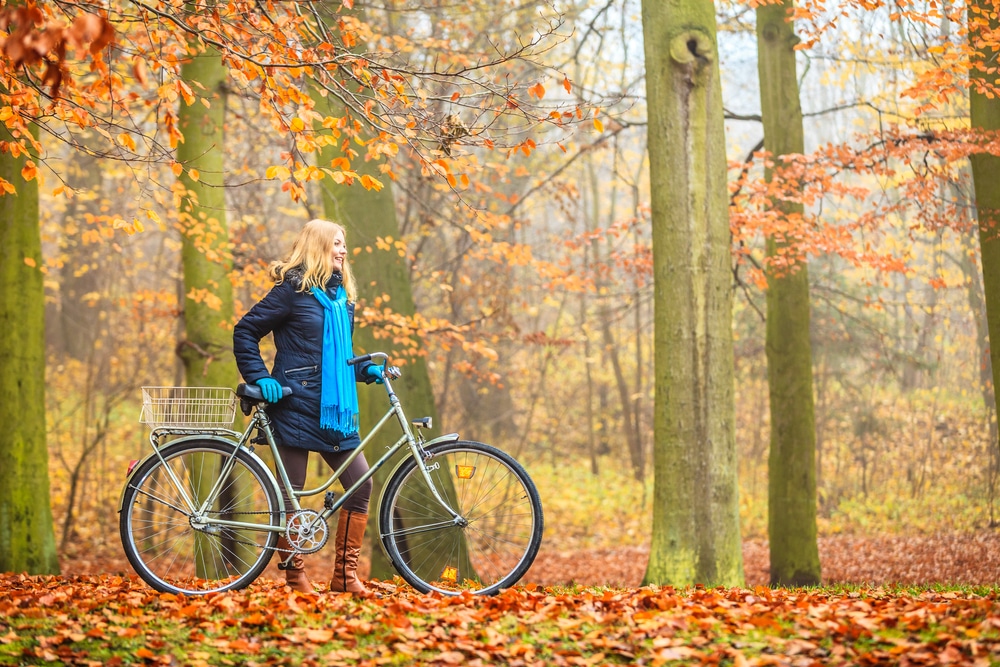 Woman riding a bike through foliage at iowa state Parks in the Okoboji area