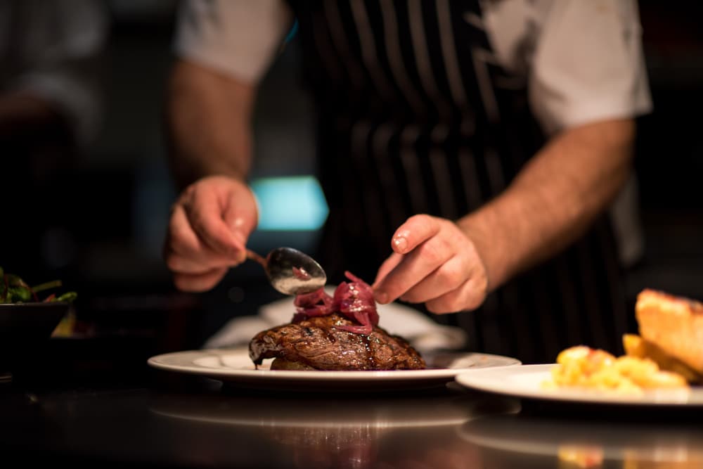 Restaurants in Okoboji, fine dining chef adding the finishing touches to a plate of food 