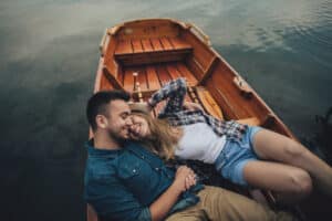 One of the best Things to do in Okoboji, IA, is hit the lake. Photo of a happy couple lounging on the lake