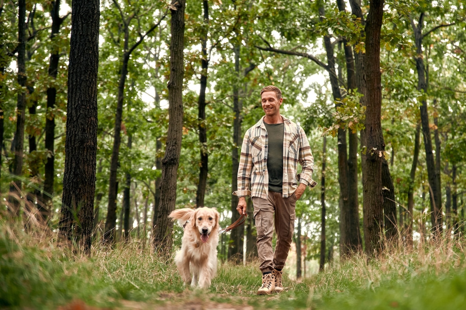 man hiking in Iowa with his dog on a beautiful wooded trail in Dickinson County