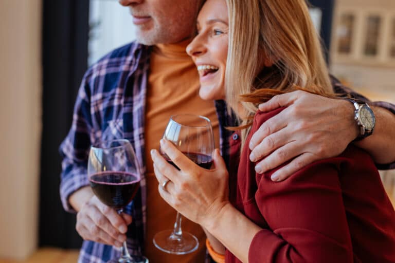 A happy man and woman enjoying a glass of wine on the Best Iowa Getaways for Couples